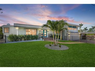 Charming home featuring a lush green lawn, elegant landscaping, and a bright blue front door at 442 22Nd Se Ave, St Petersburg, FL 33705