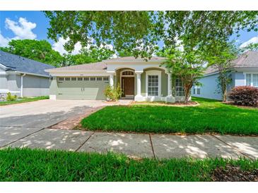 Charming single-story home with a well-manicured lawn, two-car garage and beautiful columns at the front door at 5902 War Admiral Dr, Wesley Chapel, FL 33544
