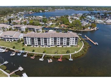 Waterfront condo building with boat docks along a canal with waterway views, showcasing coastal living at 8141 Aquila St # 346, Port Richey, FL 34668