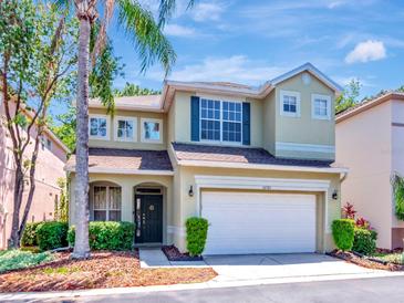 Charming two-story home with a well-manicured lawn, lush landscaping, and an attached two-car garage at 10501 Dotham Ct, Tampa, FL 33626