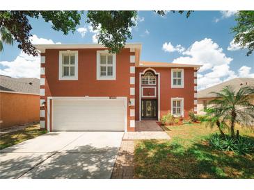 Inviting two-story home featuring an attached two-car garage and well-manicured front lawn at 13420 Copper Head Dr, Riverview, FL 33569