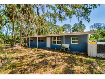Charming single-story home featuring a front porch, mature trees, and a classic design at 3226 Palmetto Rd, Wimauma, FL 33598