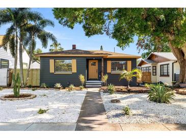 Charming home features a gray exterior, yellow shutters, and a landscaped yard at 3228 7Th N Ave, St Petersburg, FL 33713