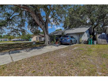 Charming single-story home with a long driveway and mature trees offering ample shade on a sunny day at 3721 140Th Ave, Largo, FL 33771