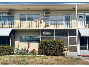 Two-story condo building featuring multiple units and exterior screened in patio at 4001 58Th N St # 18, Kenneth City, FL 33709