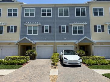 A well-maintained townhome featuring a brick driveway, attached garages, and manicured landscaping at 4053 Rocky Shores Dr, Tampa, FL 33634