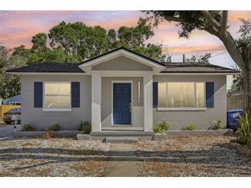 Charming single-story home features a gray exterior, dark blue door, and well-maintained landscaping at 419 40Th S Ave, St Petersburg, FL 33705