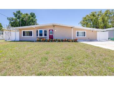 Charming single-story home features a well-manicured lawn and a vibrant red front door at 4732 W Wyoming Ave, Tampa, FL 33616
