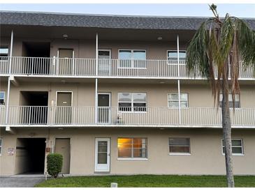 Three-story condo complex with balconies, palm trees and tan paint and white railings at 5720 13Th N Ave # 106B, St Petersburg, FL 33710