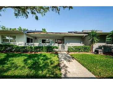 Inviting home exterior featuring a walkway, tidy landscaping, and a charming picket fence and front porch at 70 Ashley Ln, Oldsmar, FL 34677