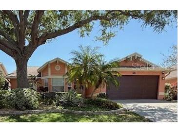 Charming single-story home with mature trees, manicured landscaping, and a spacious two-car garage at 965 Westwinds Blvd, Tarpon Springs, FL 34689