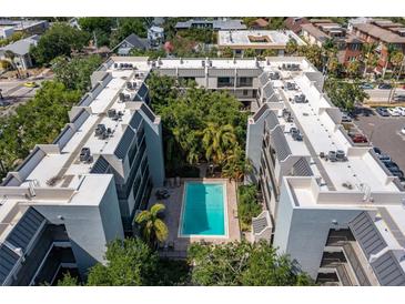 Stunning aerial view of condo building with a community pool surrounded by lush landscaping at 105 4Th Ne Ave # 219, St Petersburg, FL 33701