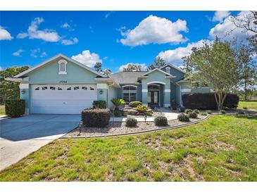 Charming single-story home with a well-manicured lawn and lovely landscaping at 17364 Mediterranean Cir, Weeki Wachee, FL 34614