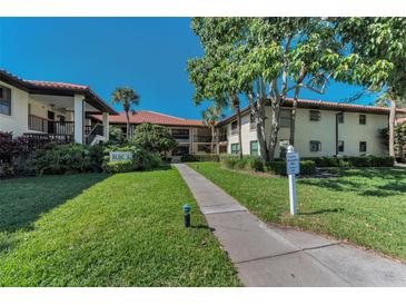 Well-maintained condo building with lush landscaping and a sidewalk leading to the entrance at 502 Hammock Pine Blvd # 502, Clearwater, FL 33761
