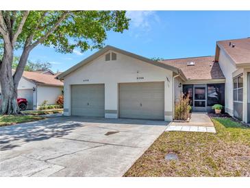 Charming single-story home with an attached two-car garage and well-maintained landscaping in a quiet neighborhood at 8206 Leafy Ct, Port Richey, FL 34668