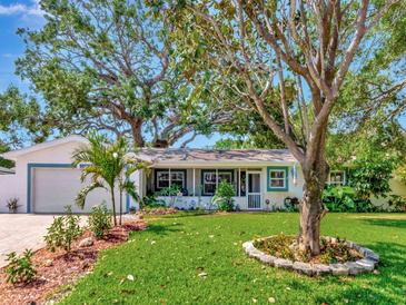 Charming single-story home with a well-manicured lawn, beautiful trees, and a cozy screened-in porch at 8326 40Th N Pl, St Petersburg, FL 33709