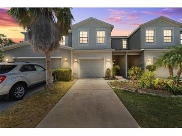 Charming townhome exterior with a one-car garage, inviting landscape, and pleasant facade at 10687 Lake Montauk Dr, Riverview, FL 33578