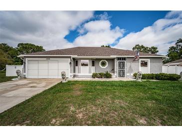 Charming single-story home with well-manicured lawn and welcoming entrance and a two car garage at 11209 Kangley Ln, Spring Hill, FL 34608