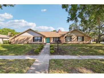 Charming single-story home featuring a well-manicured lawn, inviting entryway, and appealing brick facade at 170 Foxfire Ln, Oldsmar, FL 34677