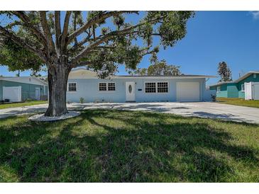 Charming single-story home featuring a large tree and a well-manicured front lawn at 3841 Wahoo Se Dr, St Petersburg, FL 33705