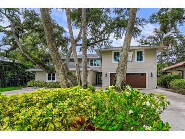 Elegant two-story home featuring lush landscaping, a two-car garage, and a well-maintained front yard at 5018 S The Riviera St, Tampa, FL 33609