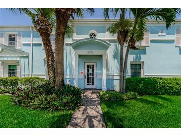 Charming light blue home featuring a white door, lush landscaping, and a welcoming brick walkway at 5094 Starfish Se Dr # E, St Petersburg, FL 33705