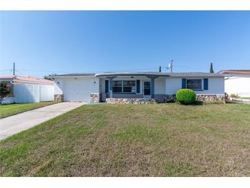Charming single-story home with well-manicured lawn, stone accents, and a classic white exterior at 5203 Overton Dr, New Port Richey, FL 34652