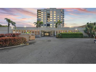 Beautiful condo building exterior with lush landscaping and convenient covered parking at 6322 Palma Del Mar S Blvd # 706, St Petersburg, FL 33715