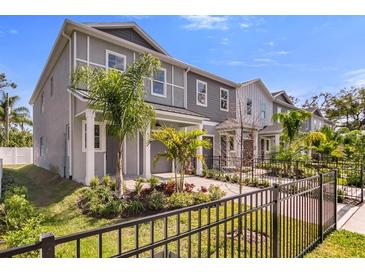 Charming townhomes featuring manicured lawns, small palm trees and decorative front fences at 5530 N 9Th St # 1, Tampa, FL 33604
