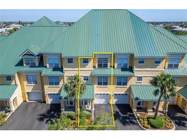 Three-story townhouse features an attached garage and a yellow stucco facade at 6451 Sunset Bay Cir, Apollo Beach, FL 33572