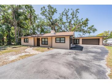 Charming single-story home with a well-manicured lawn and driveway at 8816 Memorial Hwy, Tampa, FL 33615