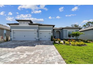 Charming single-story home featuring a three-car garage and well-manicured lawn at 11432 Shoreline Trl, Parrish, FL 34219