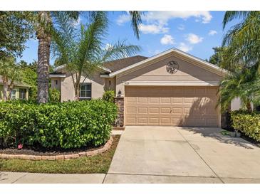 Charming single-story home with a well-manicured front yard and a two-car garage under a partly cloudy sky at 1505 Trailwater St, Ruskin, FL 33570
