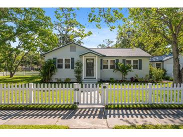 Charming single-story home with a white picket fence and a well-manicured lawn at 317 N Washington Ave, Clearwater, FL 33755