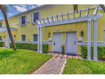 Charming townhouse entrance featuring well-maintained landscaping and a pergola over the doorways at 3751 Pompano Se Dr # 3751, St Petersburg, FL 33705