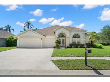 Charming single-story home boasts a three-car garage and meticulously manicured lawn at 4769 Stoneview Cir, Oldsmar, FL 34677