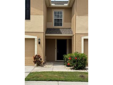 Charming townhome with neutral paint, attached garage, and inviting front entrance at 8013 Savannah Sunset Ln, Tampa, FL 33615