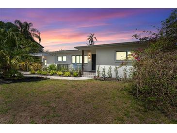 Charming home with a well-manicured lawn and beautiful landscaping at sunset at 807 W Braddock St, Tampa, FL 33603