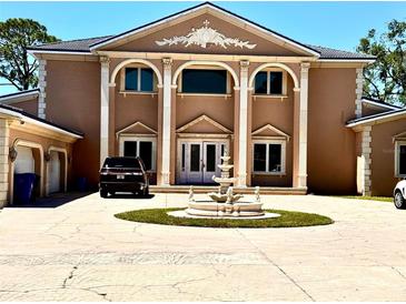 Stately home featuring prominent columns, fountain, and circular driveway, creating a grand entrance at 1516 Bayshore Blvd, Dunedin, FL 34698