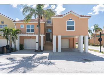 Stunning waterfront home featuring elevated construction, a two-car garage, and lush tropical landscaping at 19 Crescent S Pl, St Petersburg, FL 33711