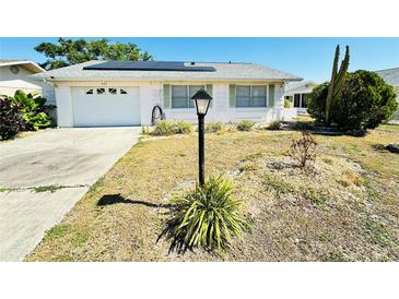Charming single-story home featuring a well-maintained front yard and a one car garage at 203 Rickenbacker Dr, Sun City Center, FL 33573