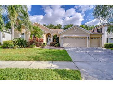 Charming single-story home boasts a lush front lawn, landscaping, and a two-car garage at 5114 Whispering Leaf Trl, Valrico, FL 33596