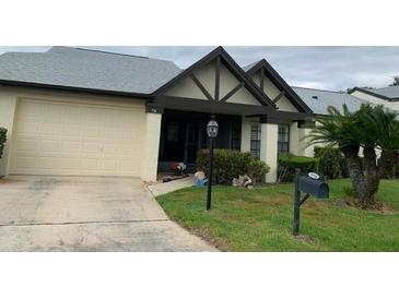 Charming home featuring an attached garage, well-maintained lawn, and inviting front entrance at 776 Lakewood Dr, Palm Harbor, FL 34684