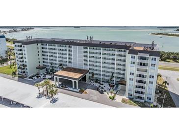 Spacious condo building featuring a porte cochere and well-maintained landscaping, offering an inviting entrance at 9 Forbes Pl # 205, Dunedin, FL 34698