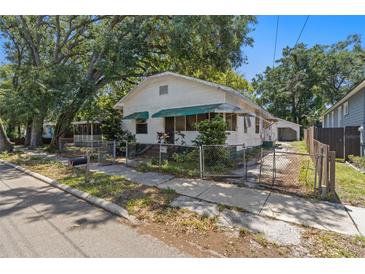 Charming single-story home with a fenced yard and mature trees offering shade at 1205 E Emma St, Tampa, FL 33603
