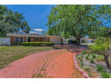 Charming single-story brick home with a red brick driveway and well-maintained landscaping at 4806 W Melrose Ave, Tampa, FL 33629