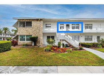 Condo exterior boasts stone accents, landscaped garden, and convenient stairwell access to upper-level units at 5915 18Th N St # 11, St Petersburg, FL 33714