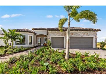 Beautiful single-story home with stone accents, tile roof, three-car garage, and lush landscaping at 5958 Talon Preserve Dr, Nokomis, FL 34275