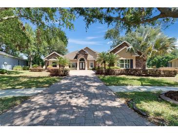 Stunning exterior showcases a lush landscape, long driveway, and a double door entry at 607 Vintage Way, Brandon, FL 33511