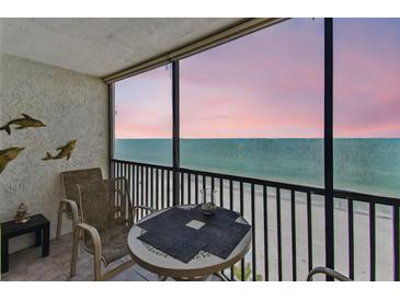 Enjoy the ocean view from this condo balcony featuring a table and chairs at 15462 Gulf Blvd # 504, Madeira Beach, FL 33708
